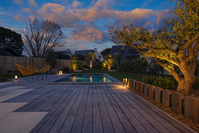 Inspiration pour un grand piscine avec aménagement paysager minimaliste rectangle avec une cour et une terrasse en bois.