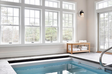 This is an example of a small traditional indoor rectangular pool in Burlington with a pool house and stamped concrete.