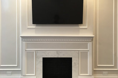 Inspiration for a mid-sized timeless formal and enclosed dark wood floor and brown floor living room remodel in New York with gray walls, a standard fireplace, a stone fireplace and a wall-mounted tv