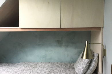 Cette image montre une petite chambre parentale bohème avec un mur vert, sol en béton ciré, aucune cheminée et un sol gris.