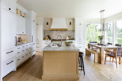 Eat-in kitchen - large transitional l-shaped light wood floor eat-in kitchen idea in Portland with a single-bowl sink, shaker cabinets, white cabinets, quartzite countertops, paneled appliances, an island and stone slab backsplash