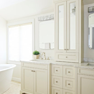 Mid-sized transitional beige tile and marble tile mosaic tile floor and beige floor freestanding bathtub photo in New York with beige cabinets, marble countertops, recessed-panel cabinets, an undermount sink and white countertops
