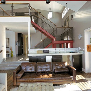 Großes, Offenes Mediterranes Wohnzimmer mit bunten Wänden, Sperrholzboden, Kamin, gefliestem Kaminsims, Wand-TV und braunem Boden in Calgary