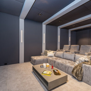 Inspiration for a huge contemporary enclosed beige floor and carpeted home theater remodel in New York with gray walls and a projector screen