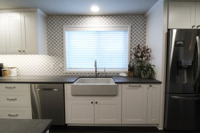 Inspiration for a mid-sized transitional galley dark wood floor and brown floor open concept kitchen remodel in Seattle with a farmhouse sink, recessed-panel cabinets, white cabinets, quartz countertops, white backsplash, ceramic backsplash, stainless steel appliances, an island and gray countertops