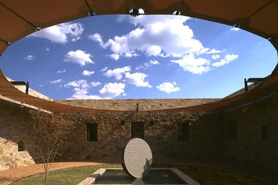 Example of a large minimalist courtyard stone patio design in Albuquerque