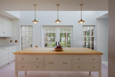 Inspiration for a mid-sized country kitchen remodel in New York with flat-panel cabinets, white cabinets, wood countertops, an island and stainless steel appliances