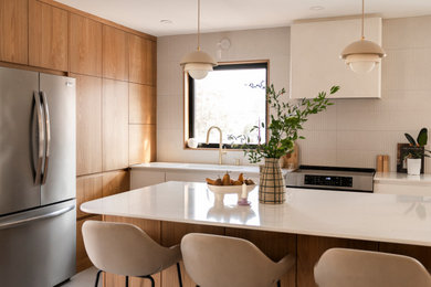 Inspiration for a mid-sized scandinavian l-shaped ceramic tile and beige floor open concept kitchen remodel in Montreal with an undermount sink, flat-panel cabinets, medium tone wood cabinets, quartzite countertops, beige backsplash, porcelain backsplash, stainless steel appliances, an island and white countertops
