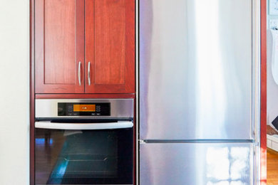 Modelo de cocina tradicional renovada con armarios estilo shaker, puertas de armario de madera oscura, encimera de granito, electrodomésticos de acero inoxidable, suelo azul y encimeras verdes