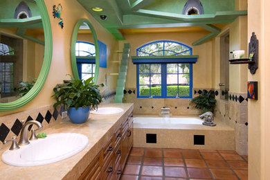 Design ideas for an eclectic bathroom in Santa Barbara with a drop-in sink, shaker cabinets, medium wood cabinets, a corner shower, beige tile, stone tile, beige walls, terra-cotta floors and an undermount tub.