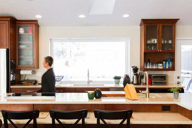 Kitchen - large transitional light wood floor kitchen idea in Denver with an undermount sink, medium tone wood cabinets, quartzite countertops, stainless steel appliances and an island