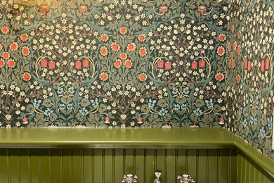 Example of a small french country wallpaper ceiling powder room design in New York with green walls