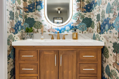 Powder room - wallpaper powder room idea in Philadelphia with medium tone wood cabinets, white countertops and a built-in vanity