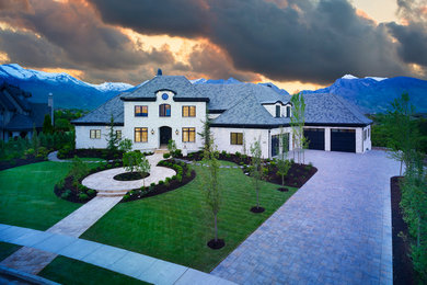 Inspiration for a huge mediterranean white three-story brick house exterior remodel in Salt Lake City with a hip roof and a shingle roof