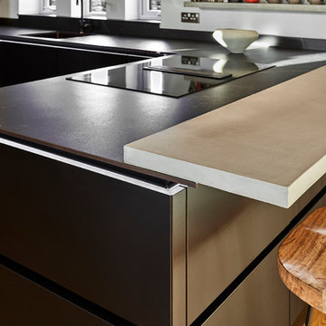 Handle-less Black kitchen with Copper accents & bespoke Concrete breakfast bar