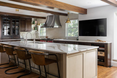 Example of a classic exposed beam kitchen design in Denver with glass-front cabinets, dark wood cabinets, quartzite countertops, stainless steel appliances, an island and white countertops