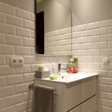Lavabo con mueble de panel liso y revestimientos de baldosa tipo metro