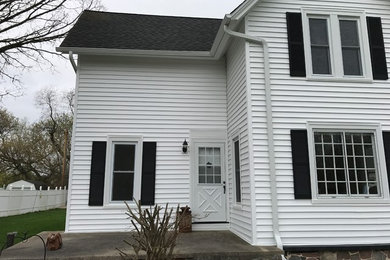 Mid-sized farmhouse concrete front porch photo in Milwaukee with a roof extension