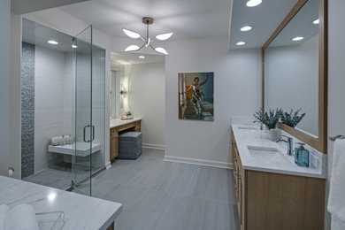 Shower bench - mid-sized transitional master gray tile and ceramic tile ceramic tile, gray floor and double-sink shower bench idea in Chicago with flat-panel cabinets, beige cabinets, a one-piece toilet, white walls, an undermount sink, quartzite countertops, a hinged shower door, white countertops and a built-in vanity