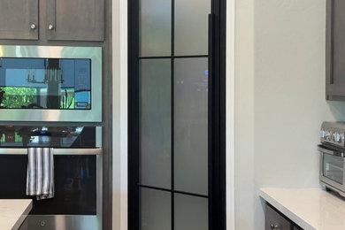 Example of a mid-sized trendy single-wall porcelain tile and beige floor open concept kitchen design in Phoenix with shaker cabinets, brown cabinets, granite countertops, stainless steel appliances, an island and white countertops