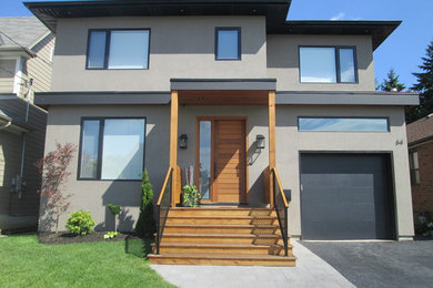 Inspiration for a large contemporary two-storey stucco grey exterior in Toronto.