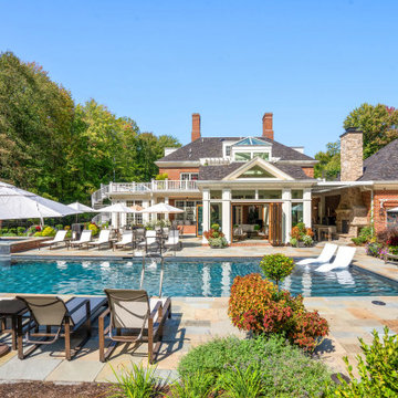 All-glass cabana opens to the pool with in-water loungers and patio dining