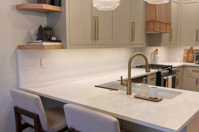 Large transitional galley medium tone wood floor enclosed kitchen photo in Atlanta with a single-bowl sink, shaker cabinets, green cabinets, quartz countertops, beige backsplash, quartz backsplash, stainless steel appliances, no island and beige countertops