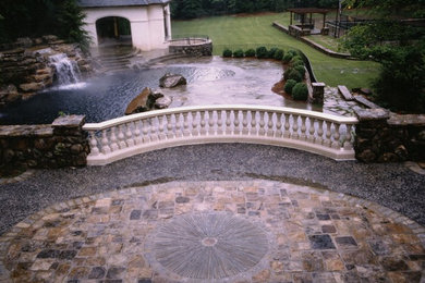 Diseño de jardín ecléctico grande en patio trasero con fuente, exposición parcial al sol y adoquines de piedra natural