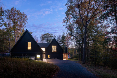 Example of a large danish black two-story mixed siding and board and batten exterior home design in Minneapolis with a shingle roof and a black roof