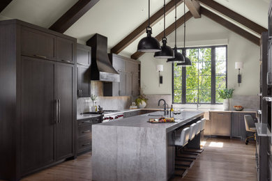 Example of a large country u-shaped vaulted ceiling kitchen design in Denver with recessed-panel cabinets, dark wood cabinets, paneled appliances and an island