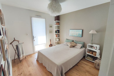Modelo de dormitorio beige y blanco marinero pequeño con paredes beige y suelo de madera clara