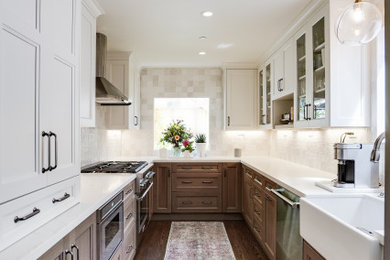 Example of a mid-sized transitional u-shaped medium tone wood floor and brown floor kitchen design in San Francisco with a farmhouse sink, shaker cabinets, medium tone wood cabinets, quartz countertops, white backsplash, terra-cotta backsplash, stainless steel appliances, no island and white countertops