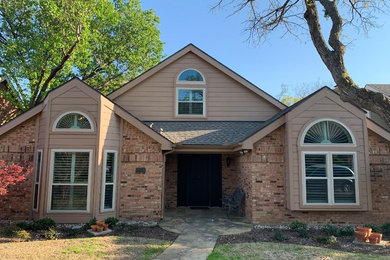 Mid-sized traditional beige two-story brick exterior home idea in Dallas with a shingle roof