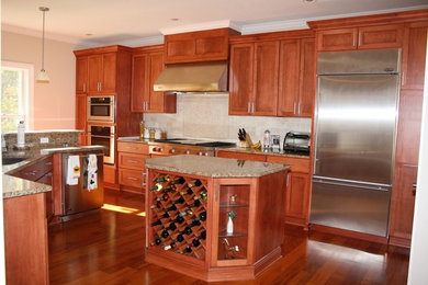 Moderne Küche mit Unterbauwaschbecken, Schrankfronten mit vertiefter Füllung und Küchengeräten aus Edelstahl in Sonstige
