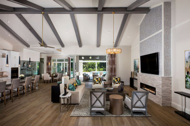 Large transitional open concept family room in Miami with grey walls, medium hardwood floors, a standard fireplace, a tile fireplace surround and brown floor.