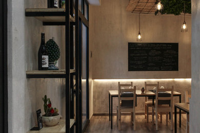 Foto di una sala da pranzo aperta verso il soggiorno industriale di medie dimensioni con pareti bianche e parquet scuro