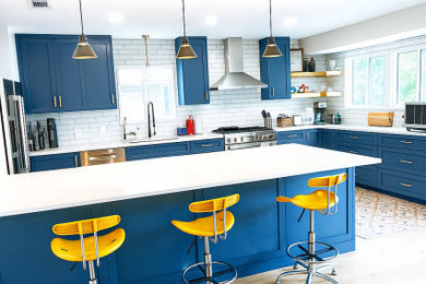 Mid-sized minimalist u-shaped ceramic tile and yellow floor eat-in kitchen photo in Austin with an undermount sink, shaker cabinets, blue cabinets, quartz countertops, white backsplash, subway tile backsplash, stainless steel appliances, a peninsula and white countertops
