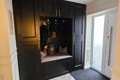 This is an example of a contemporary boot room in Other with a single front door, a white front door and a feature wall.