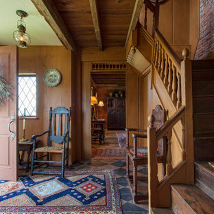 ボストンの片開きドアカントリー風おしゃれな玄関ロビー (濃色木目調のドア、塗装フローリング) の写真