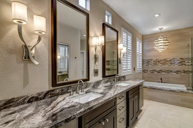 This is an example of a mid-sized transitional master bathroom in San Diego with an undermount sink, furniture-like cabinets, dark wood cabinets, marble benchtops, a drop-in tub, a corner shower, a two-piece toilet, beige tile, porcelain tile, beige walls and porcelain floors.
