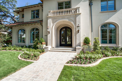 Inspiration for a large mediterranean beige two-story stucco exterior home remodel in Dallas