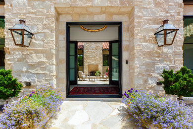 Example of a tuscan beige stone house exterior design in Kansas City