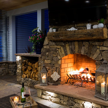 Covered outdoor area with fireplace, grill island and paver patio