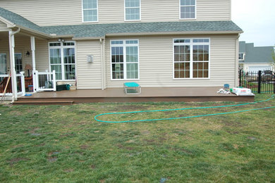 Inspiration for a mid-sized transitional back porch remodel in Other with decking