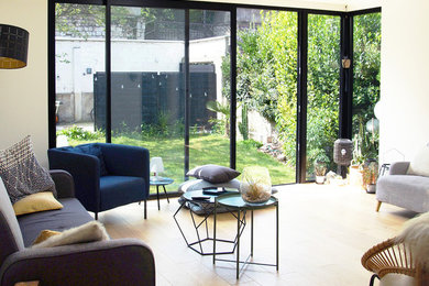 Aménagement d'un salon contemporain de taille moyenne et ouvert avec un mur blanc, parquet clair et un sol marron.