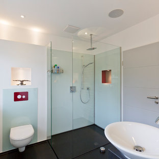 Esempio di una stanza da bagno con doccia minimalista di medie dimensioni con doccia a filo pavimento, WC a due pezzi, piastrelle blu, lastra di vetro, pareti bianche, lavabo a bacinella, top in granito, pavimento nero, doccia aperta e top nero