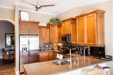 Kitchen - mid-sized u-shaped ceramic tile and vaulted ceiling kitchen idea in Other with an undermount sink, shaker cabinets, brown cabinets, wood countertops, mosaic tile backsplash, stainless steel appliances and brown countertops