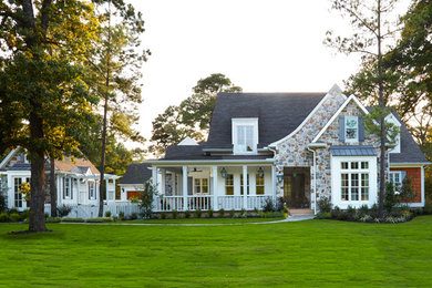 Photo of a large traditional two-storey white house exterior in Houston with mixed siding and a hip roof.