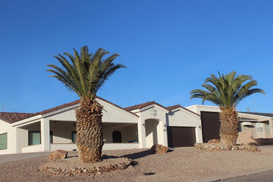 Example of a large southwest beige one-story adobe exterior home design in Phoenix with a tile roof and a brown roof