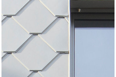 Стильный дизайн: двухэтажный, серый таунхаус среднего размера в современном стиле с облицовкой из металла, двускатной крышей и черепичной крышей - последний тренд